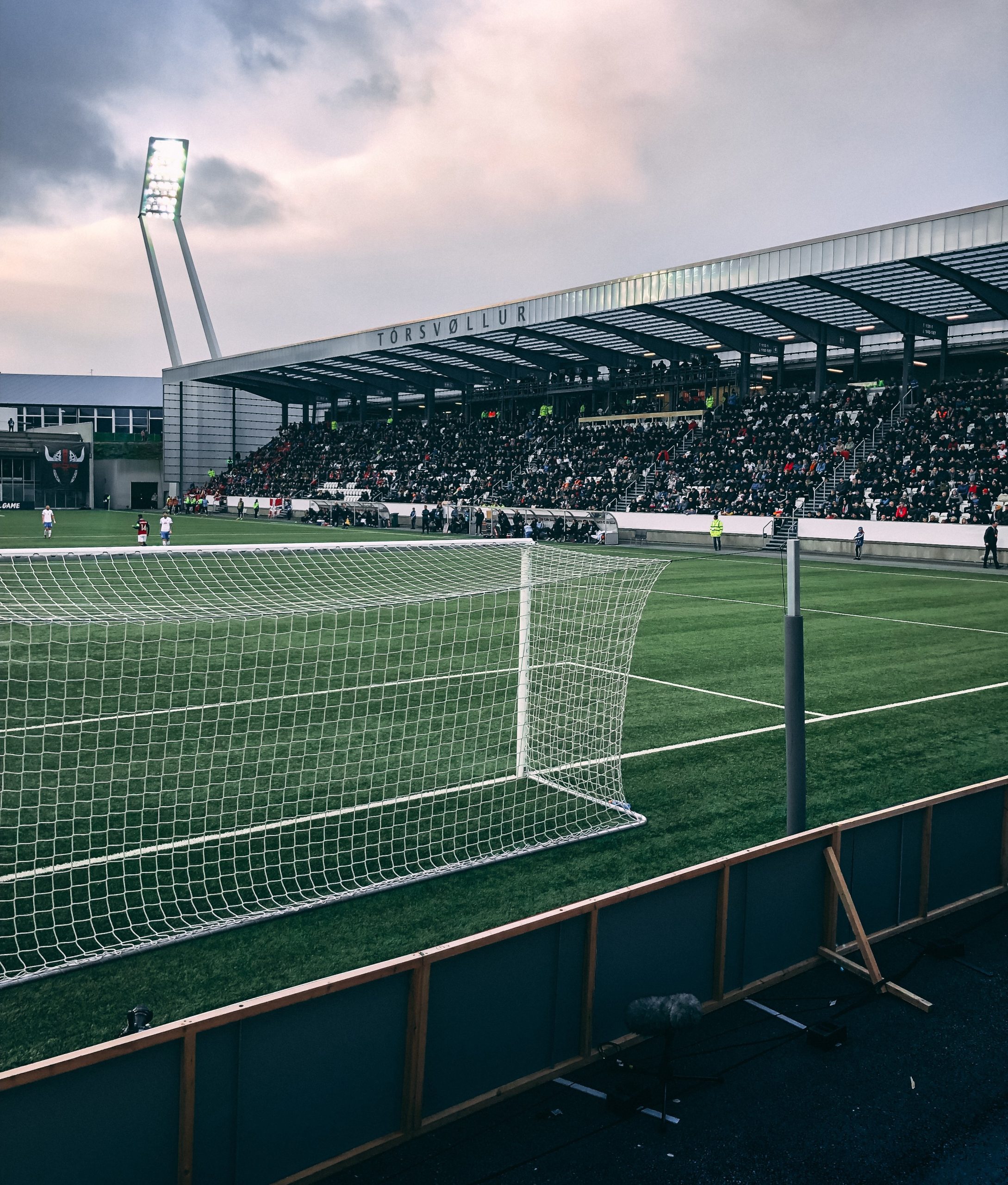 A vertical shot of crowded soccer stadium under cloudy sky