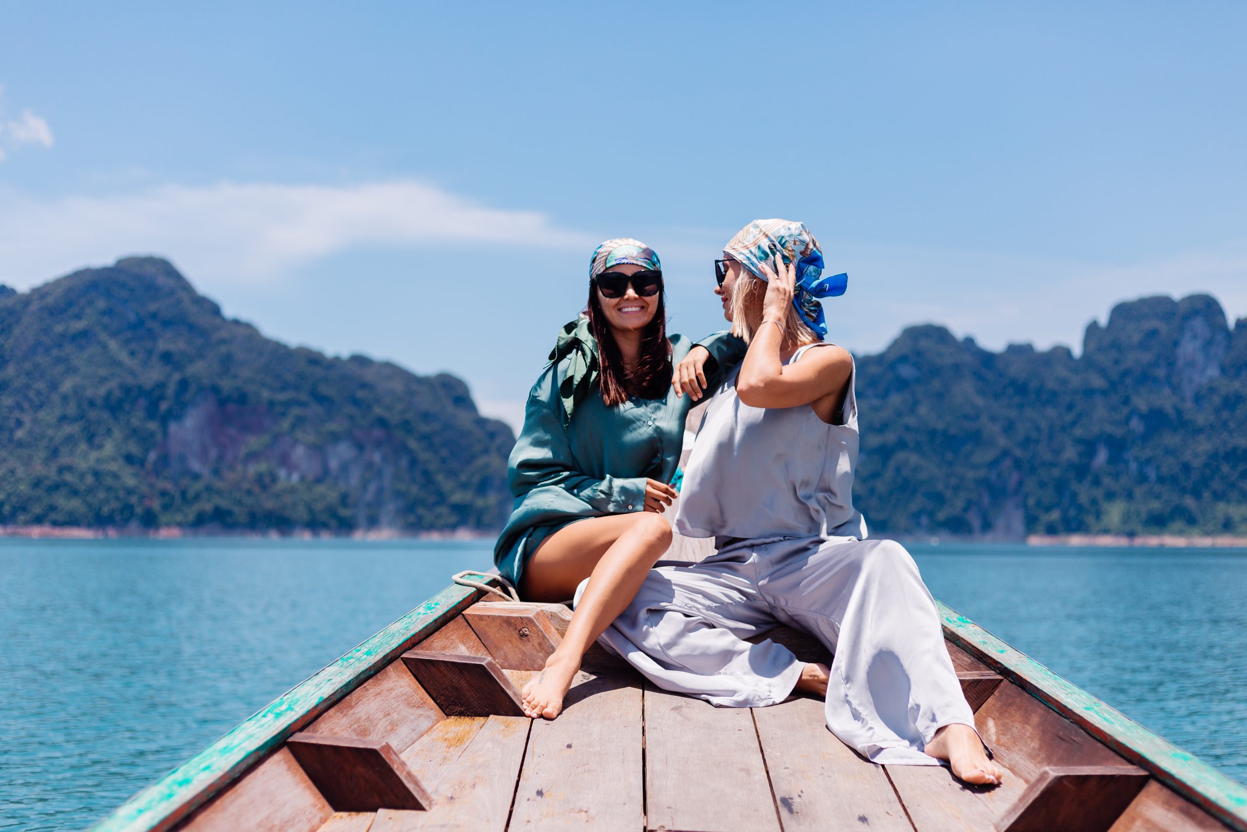 https://bizzplushq.com/wp-content/uploads/2023/12/two-happy-woman-blogger-tourist-friends-silk-suit-scarf-sunglasses-vacation-travel-around-thailand-asian-boat-khao-sok-national-park-scaled.jpg